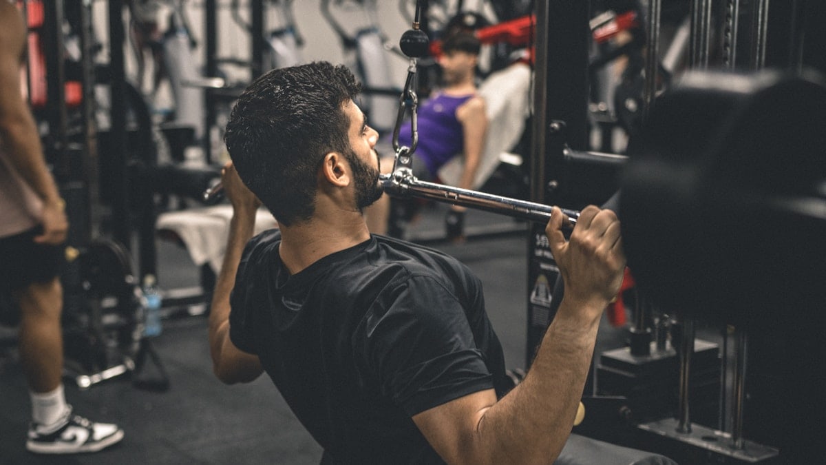 a man in a gym lifting a bar